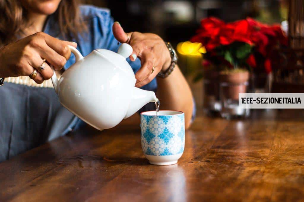 unknown person holding white ceramic kettle